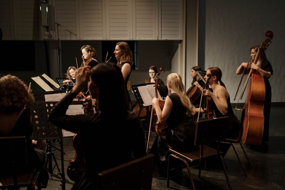 Ein musikar framfører eit stykke i ein konsertsal, med eit andektig publikum.