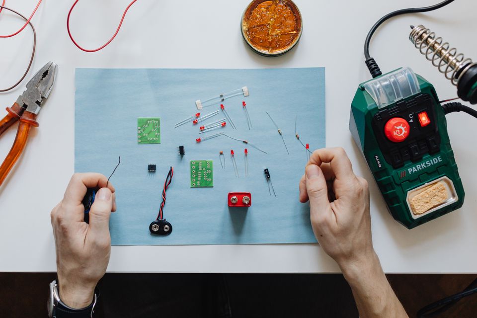 Gamle Elektor-blad og ulike elektronikk-komponentar ligg framme på eit arbeidsbord.